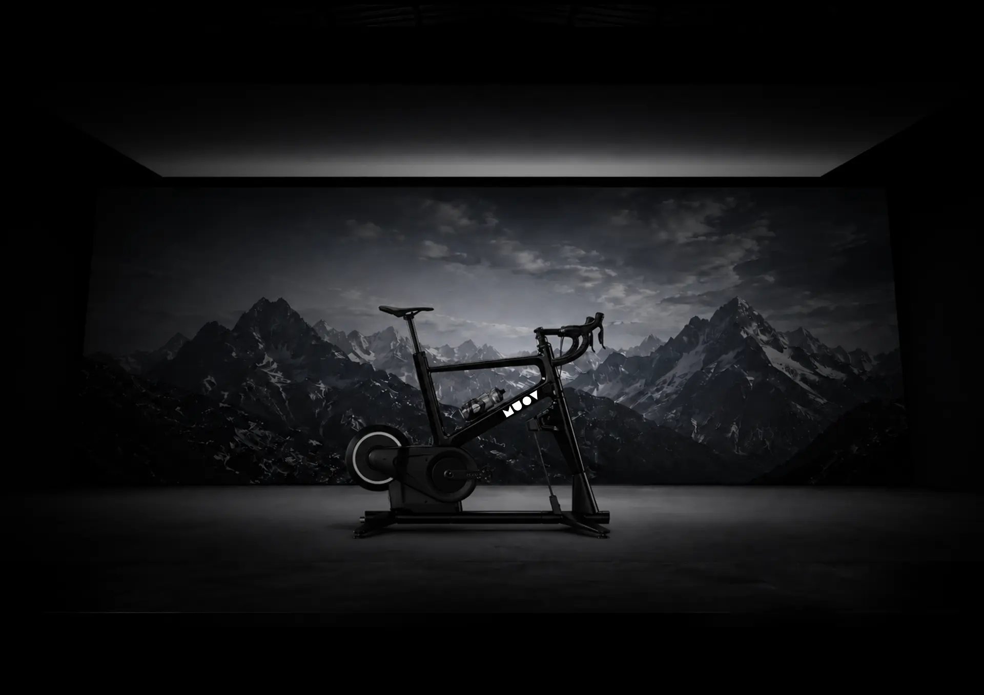 MUOV bike in a dark studio against a mountain projection