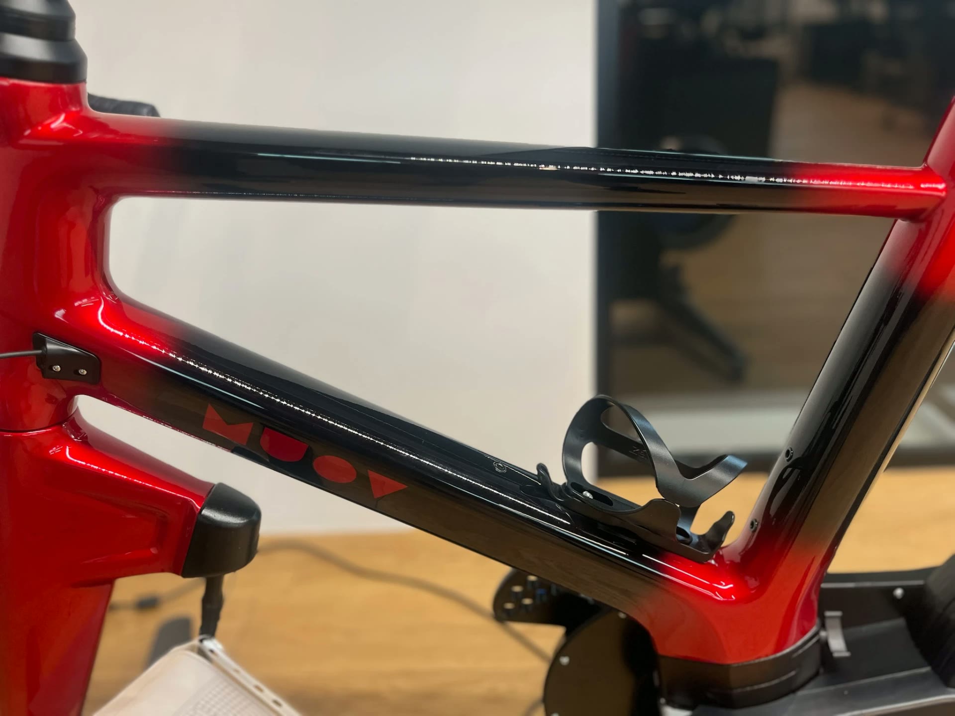 Close view of a MUOV frame where red paint transitions into gloss black along the top tube